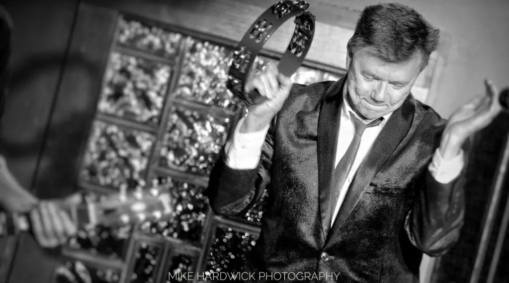 Mark Engebretson shaking a tambourine.